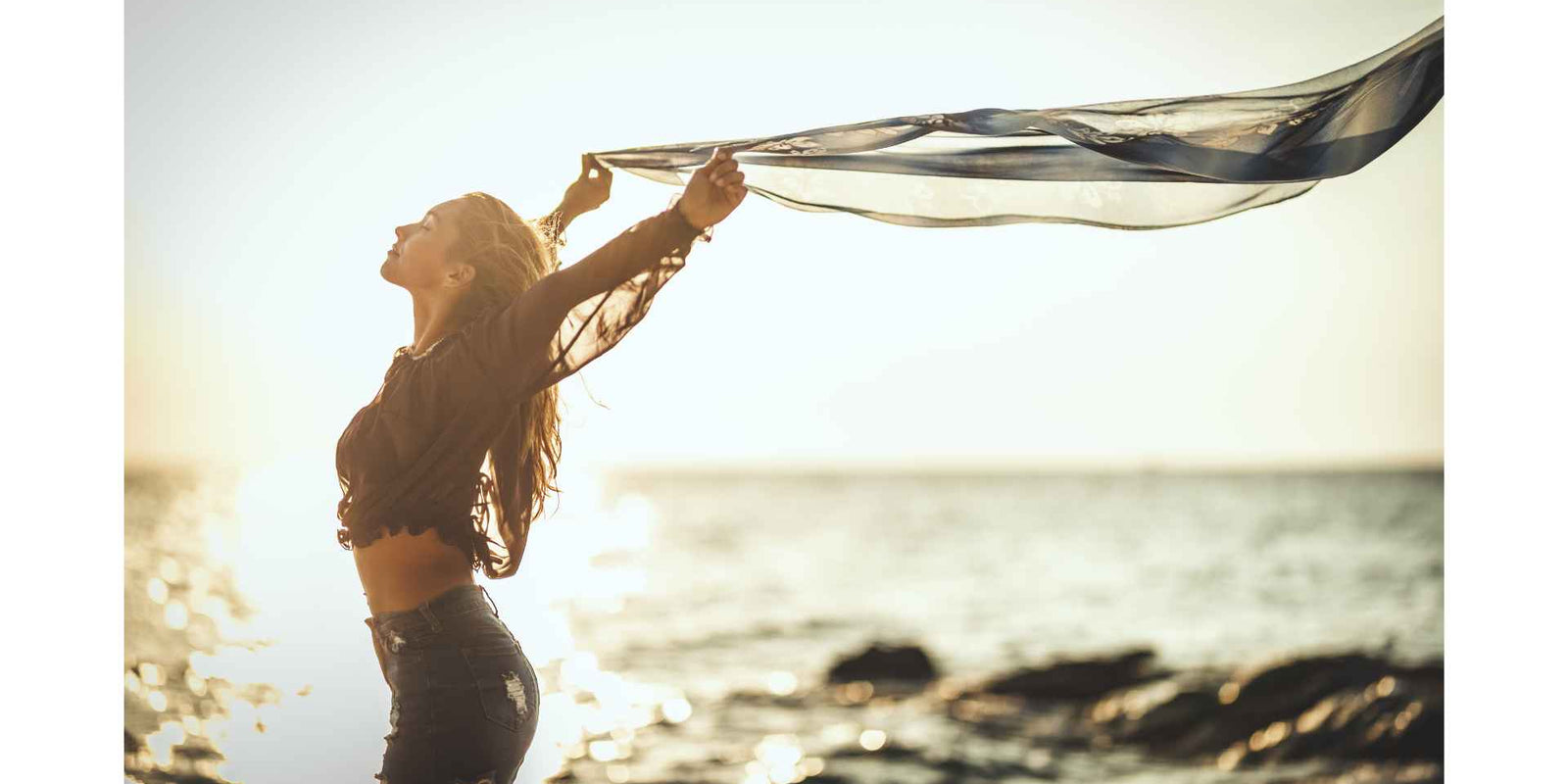 femme au bord de la plage qui lache un voile