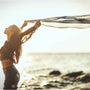 femme au bord de la plage qui lache un voile